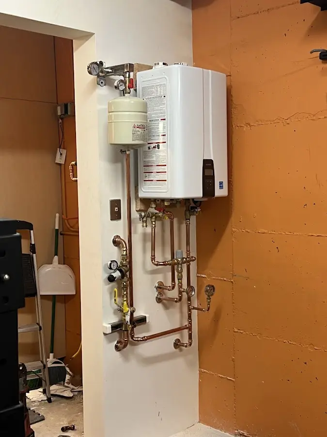 Plumbing technician inspecting water heater connections in Ottawa Hills